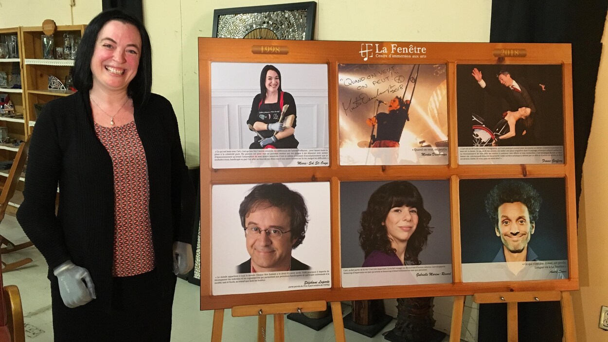 Souriante, une femme avec des mains bioniques pose avec, à sa gauche, un tableau affichant le visage de six personnes.