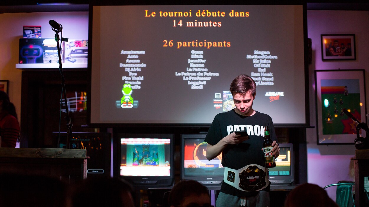 Félix Locas regarde son téléphone avant le début d'un tournoi.