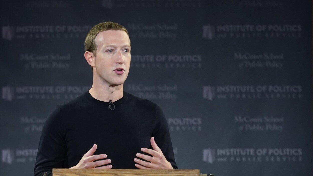 Mark Zuckerberg, debout derrière un lutrin en bois, s'adresse à un public.
