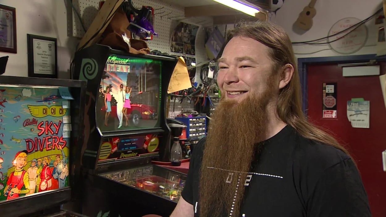 Marshall Charlebois devant des machines d'arcades.