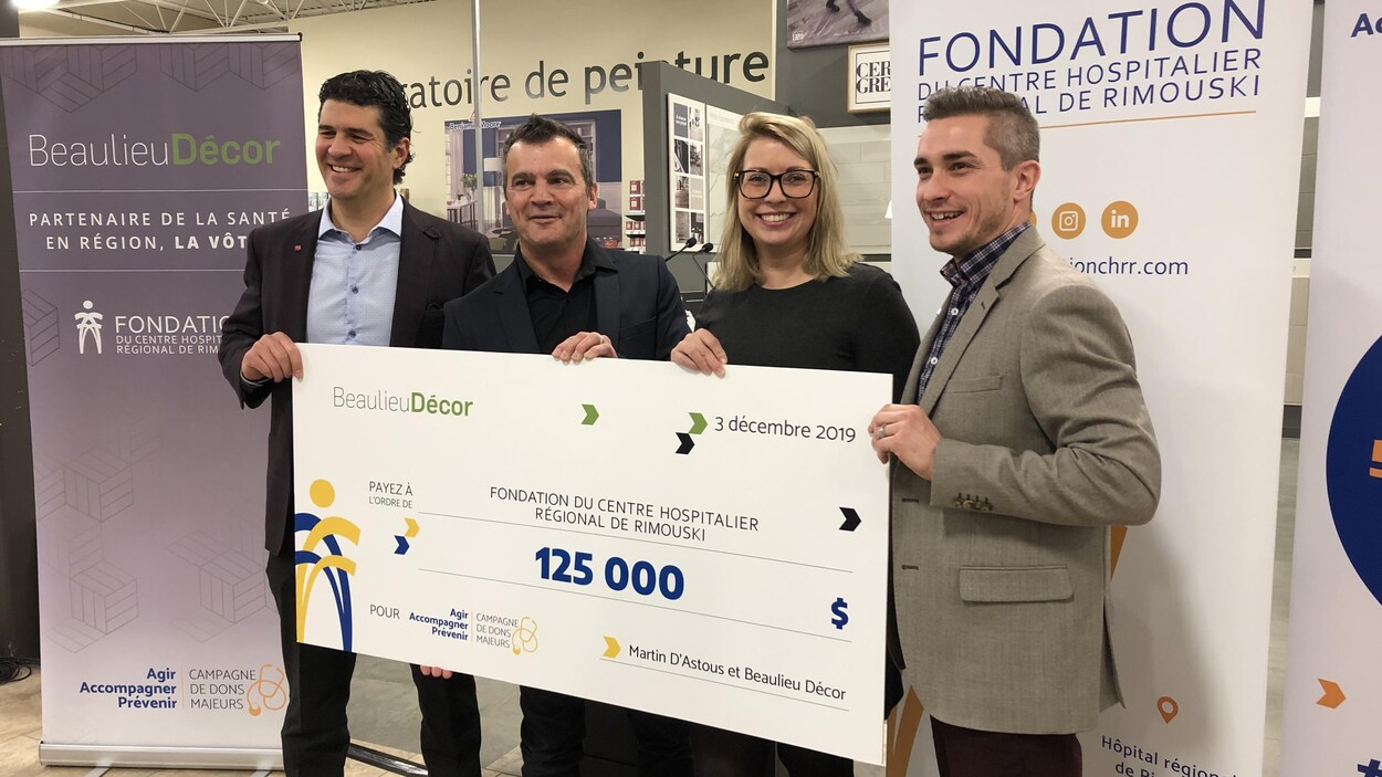 Martin D'Astous prend la pose avec un chèque géant, entouré de responsables de la Fondation du Centre hospitalier de Rimouski.