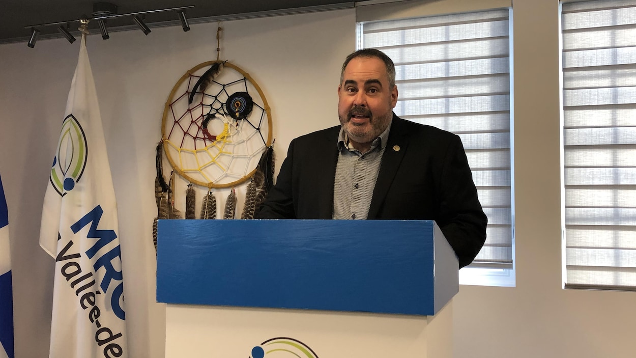 Martin Ferron parle derrière un lutrin avec le logo de la MRC.