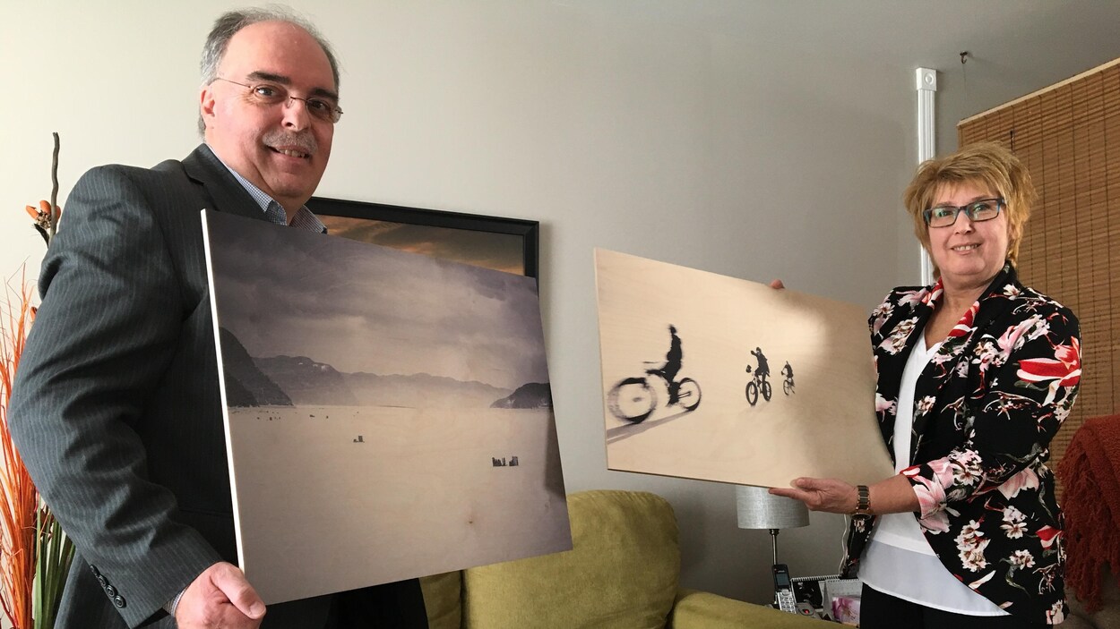 Un homme et une femme tiennent dans leur main une photo.