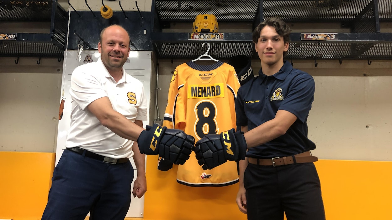 Martin Mondou et Isaac Ménard prennent la pose dans un vestiaire de hockey.