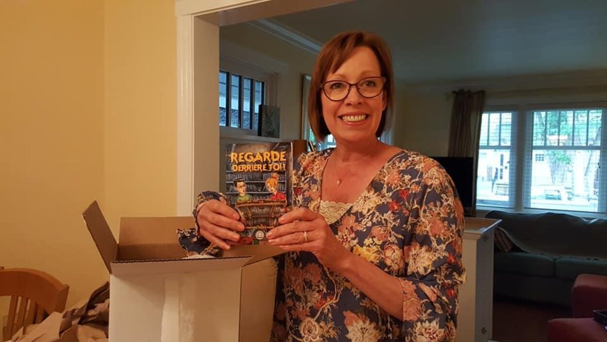 Martine Noël-Maw tient son nouveau livre en souriant à la caméra. Martine Noël-Maw tient son nouveau livre en souriant à la caméra.