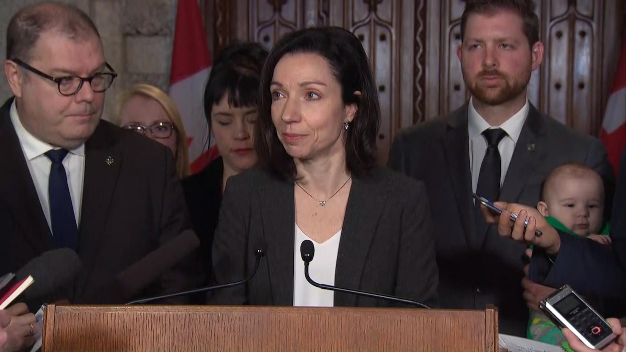 La chef du Bloc québécois, Martine Ouellet, répond aux questions des journalistes sous le regard du député Mario Beaulieu (à gauche), le 28 février 2018. La chef du Bloc québécois, Martine Ouellet, répond aux questions des journalistes sous le regard du député Mario Beaulieu (à gauche), le 28 février 2018.