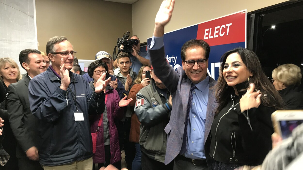 Le député Marty Morantz lève la main en signe de victoire, au milieu d'une petite foule qui l'applaudit.