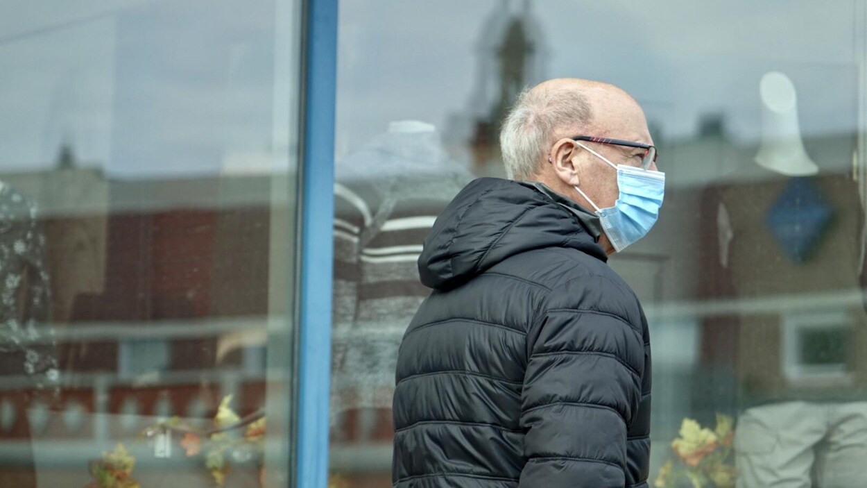 Un piéton portant un masque.