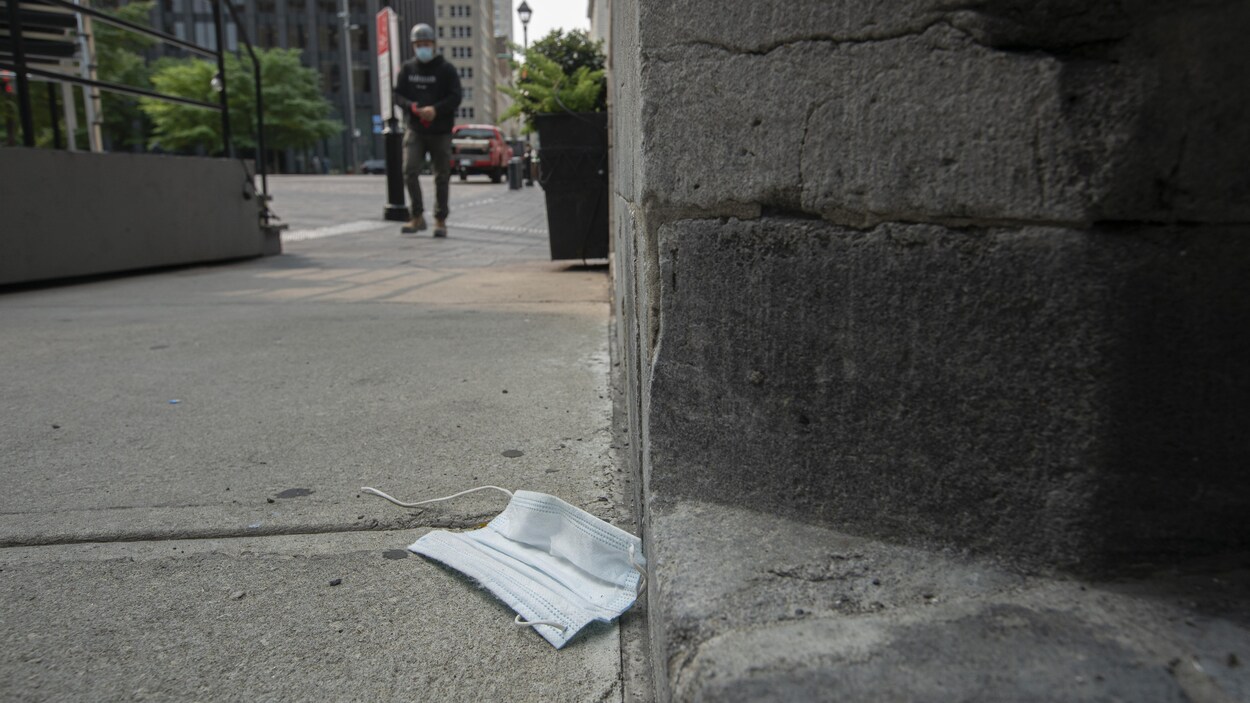Un masque traîne sur le sol, dans une rue de Montréal.