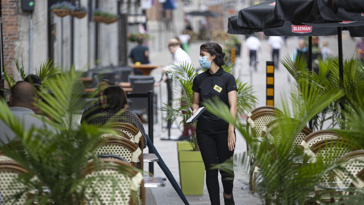 Quelques clients assis sur une terrasse d'un restaurant du Vieux-Montréal.