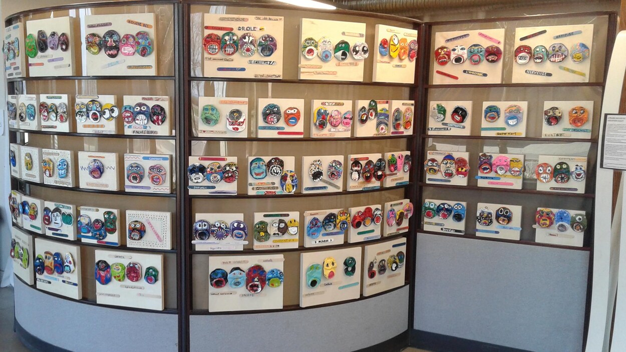 Des masques exposés sur un mur circulaire.