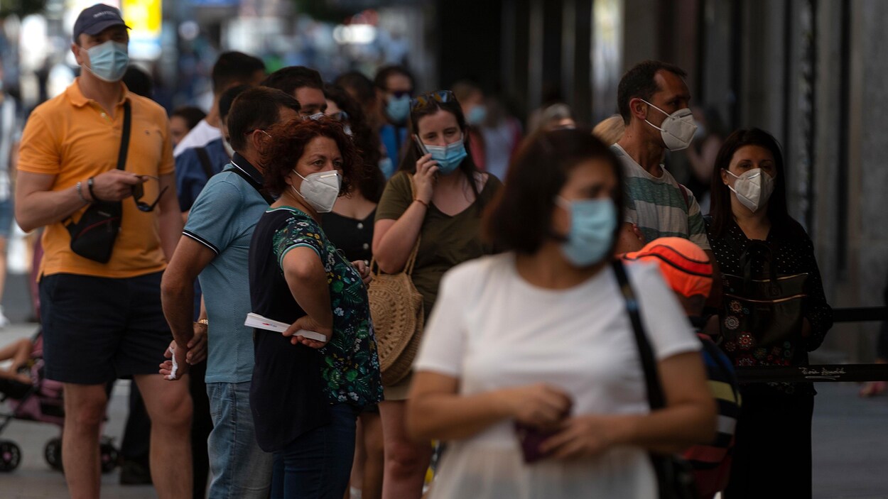 Des Espagnols portant des masques dans la rue.