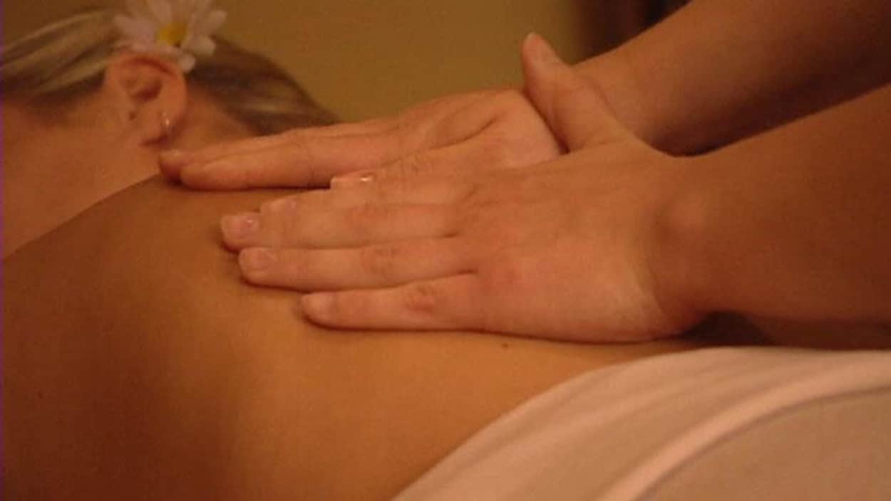 Gros plan sur les mains sur le dos d'une femme lors d'un massage. Gros plan sur les mains sur le dos d'une femme lors d'un massage.