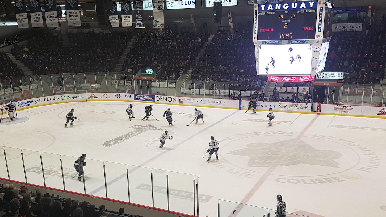 Des centaines de partisans regardent des joueurs en action sur la patinoire.