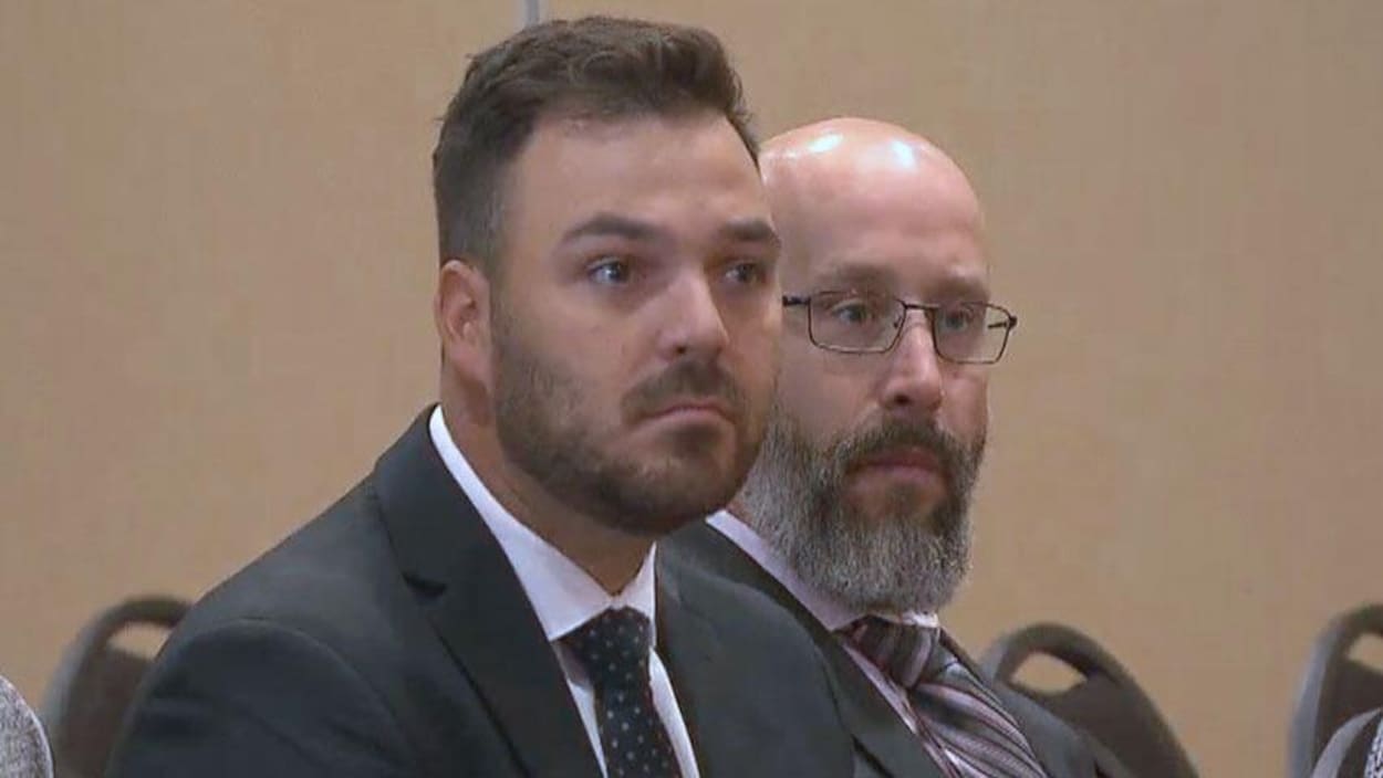 Les policiers Mathieu Boudreau (à gauche) et Patrick Bulger écoutent les délibérations aux audiences d'arbitrage à Bathurst.