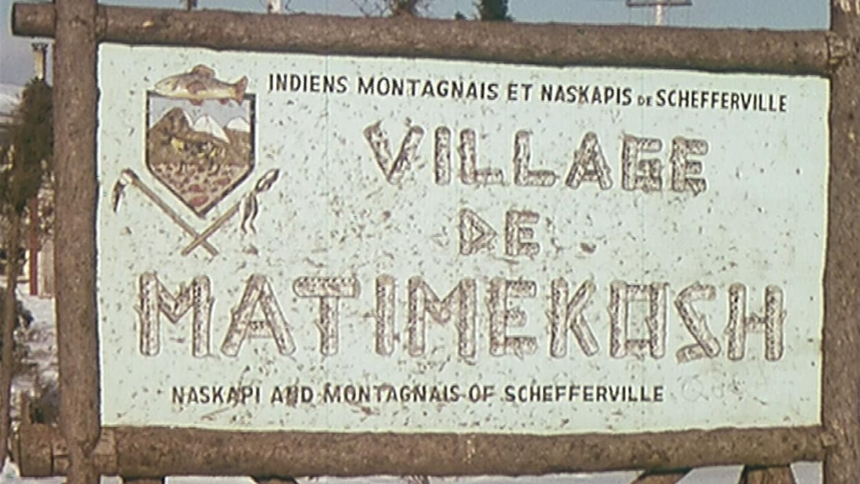 Un panneau en rondins sur lequel on peut lire Village de Matimekush, indiens montagnais et naskapis de Schefferville