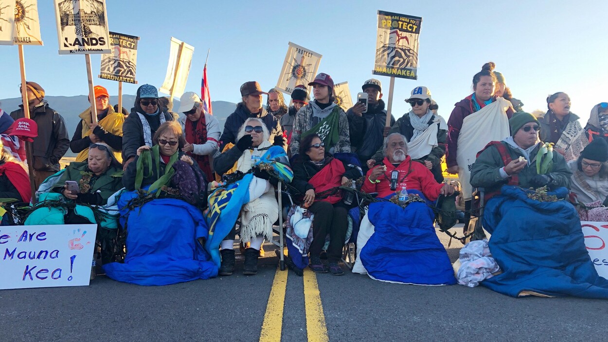Une rangée de manifestants bloque une route d'Hawaï.