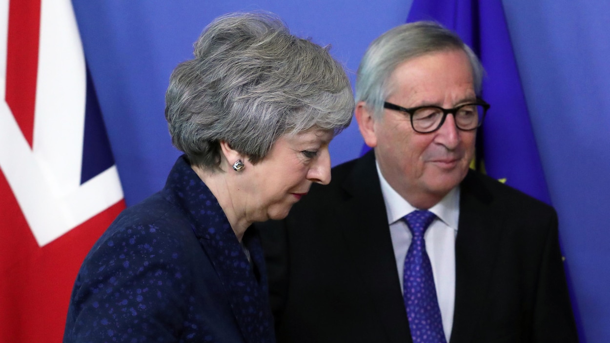 Theresa May vue de profil aux côtés de Jean-Claude Juncker.