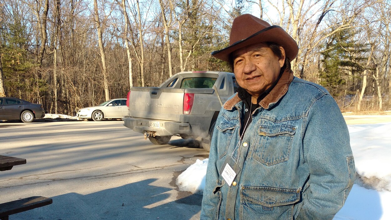 Vêtu d'un chapeau de cowboy brun et d'une veste en denim, il occupe le stationnement à l'entrée du parc. Vêtu d'un chapeau de cowboy brun et d'une veste en denim, il occupe le stationnement à l'entrée du parc.