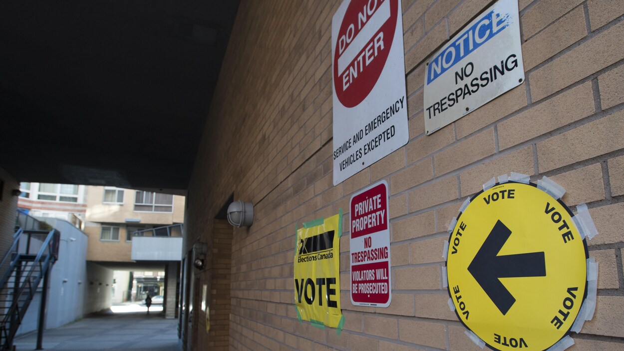 Des panneaux indiquent l'emplacement d'un bureau de vote par anticipation, alors que d'autres semblent les contredire, soulignant une interdiction de passage. La photo a été prise dans la région de Toronto Centre, à la coopérative domiciliaire Muriel Collins, le 11 octobre 2019.