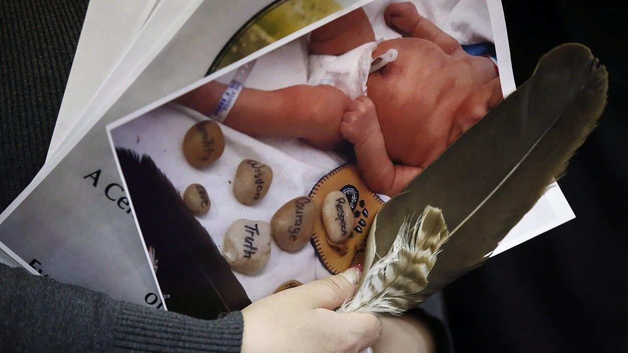 Photo d'un enfant entouré de pierres sur lesquelles sont écrits, en anglais, les mots respect, courage, sagesse, vérité et amour.