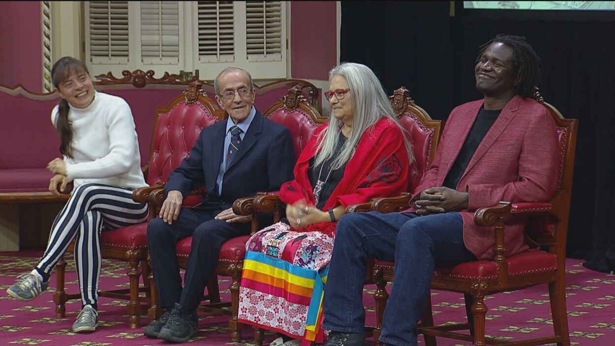 Quatre personnes assises côte à côte sur des chaises au Salon rouge de l'Assemblée nationale.