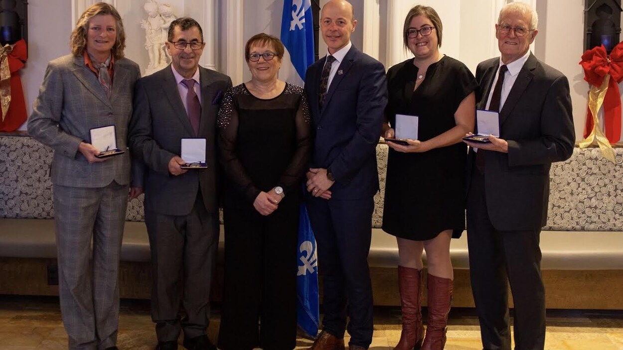 Ils posent fièrement avec leur médaille respective.