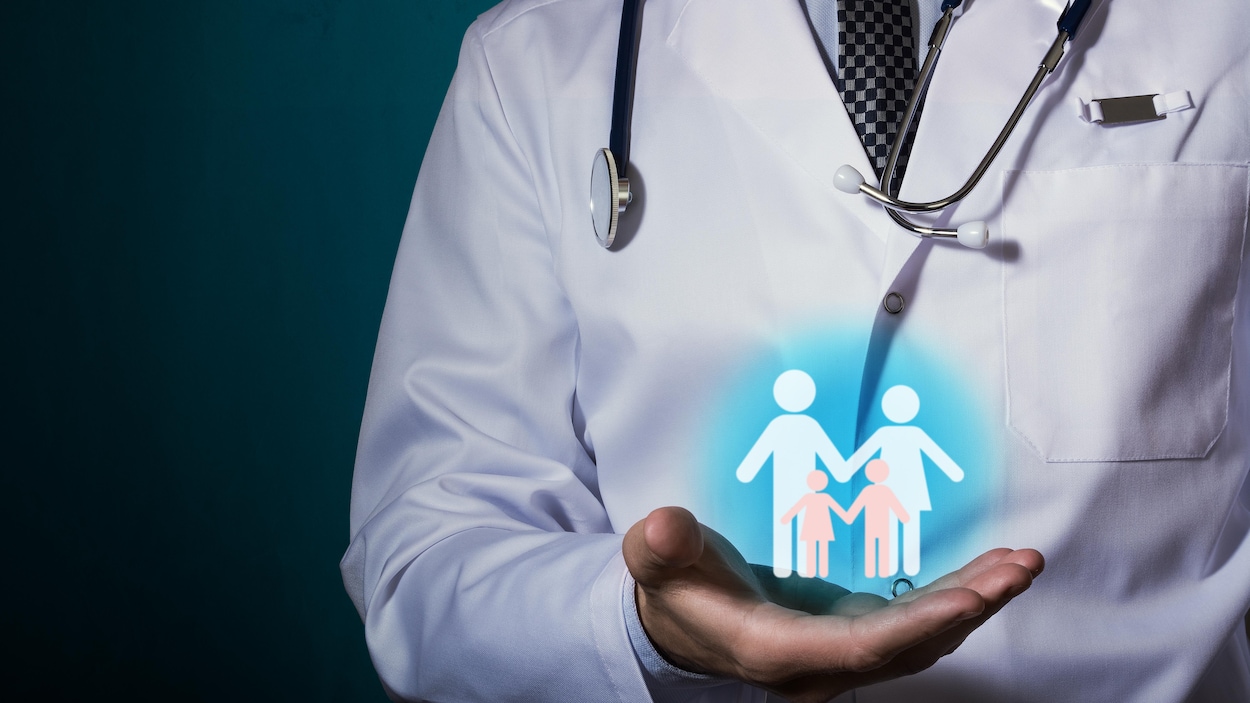 Un médecin avec dans sa main l'image d'une famille de quatre personnes. Un médecin avec dans sa main l'image d'une famille de quatre personnes.