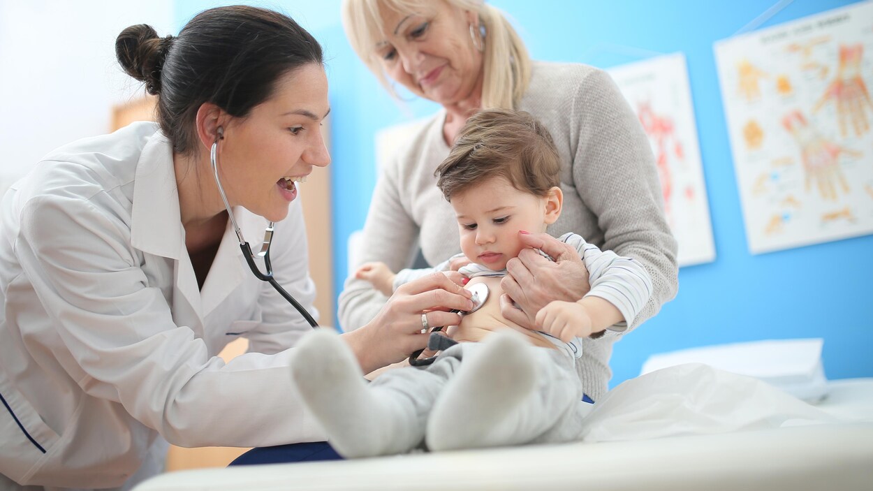 Un médecin examine un enfant à l'aide d'un stéthoscope. Un médecin examine un enfant à l'aide d'un stéthoscope.