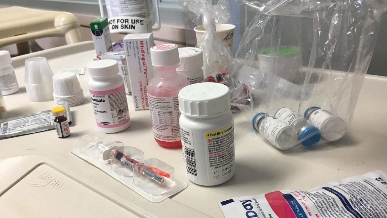 Des bouteilles de médicaments et des seringues sur une table d'hôpital.