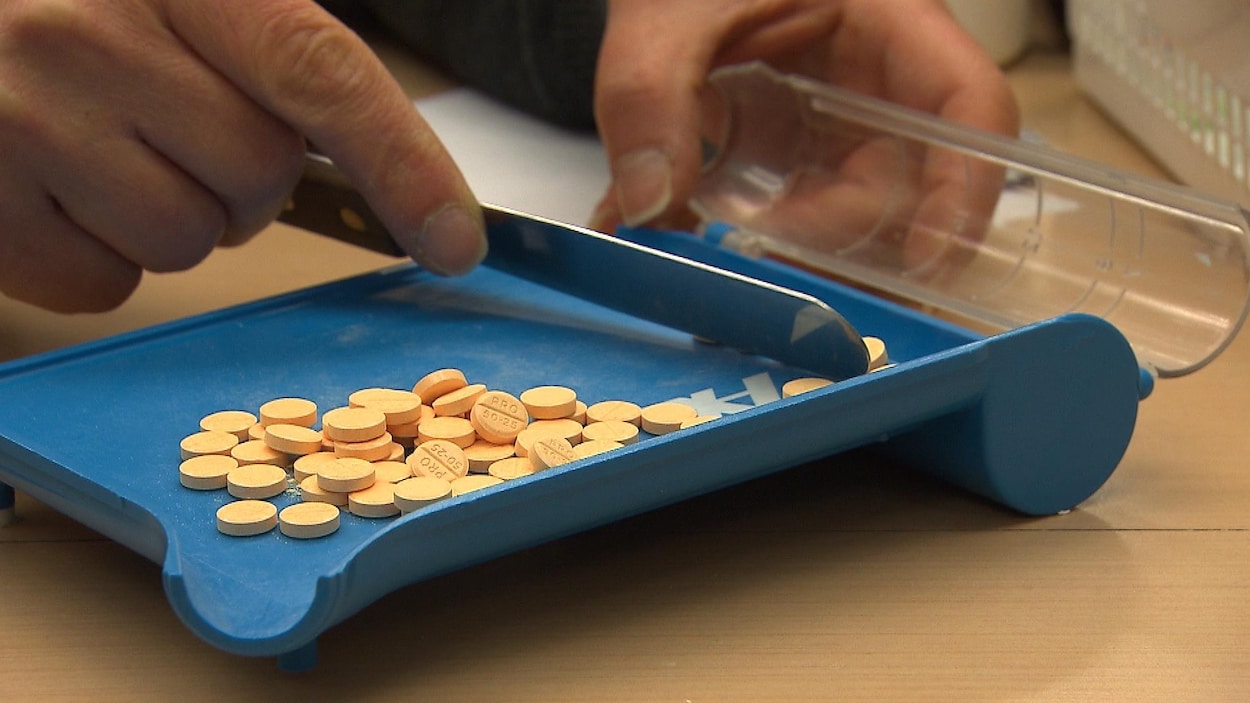 Des comprimés d'un médicament, alors qu'une pharmacienne les compte. Des comprimés d'un médicament, alors qu'une pharmacienne les compte.