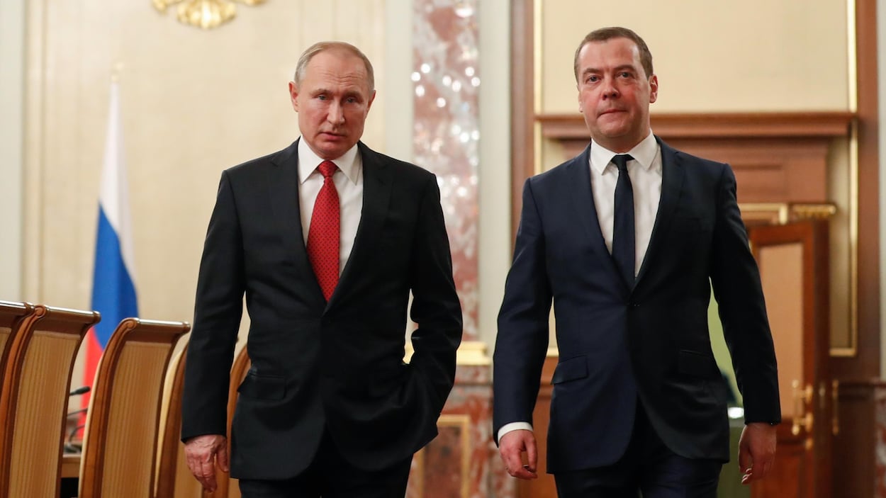 Vladimir Poutine et Dimitri Medvedev marchent dans une salle de réception du Kremlin à Moscou.