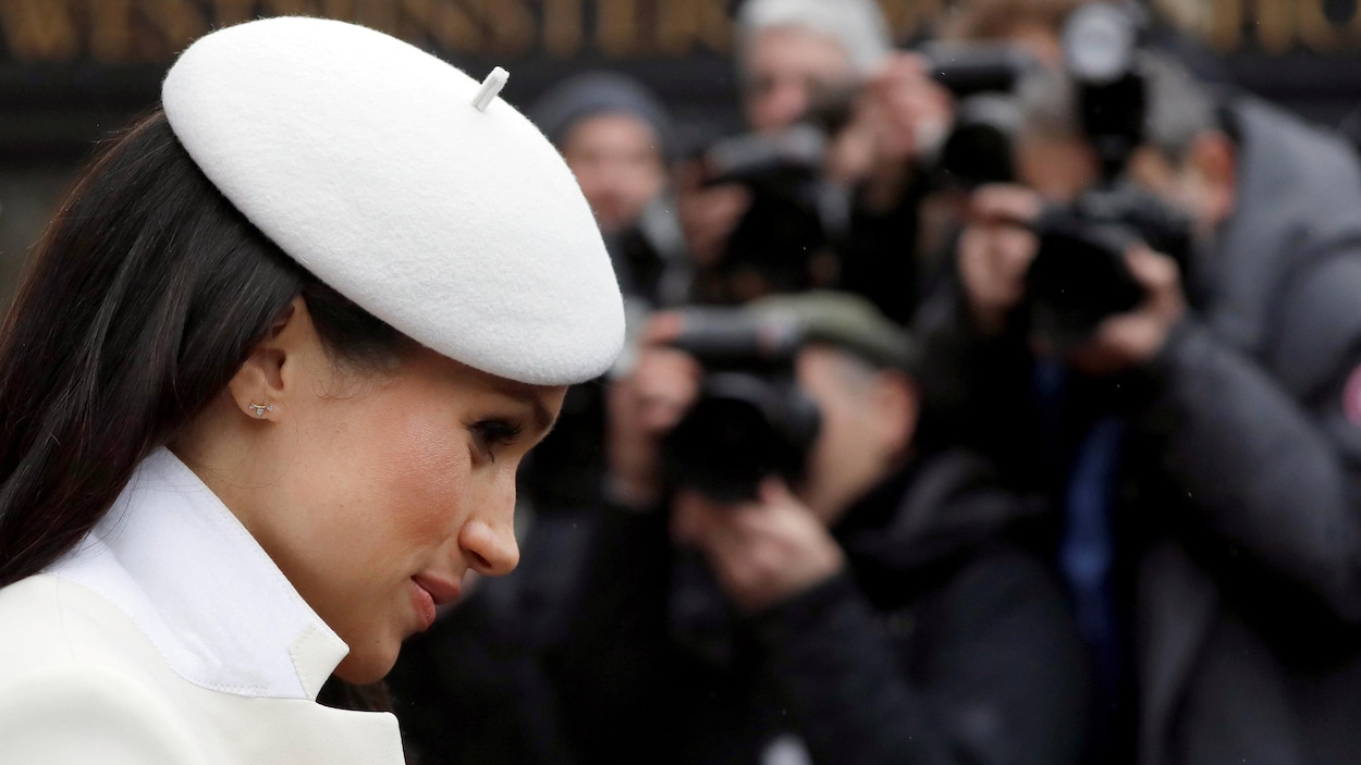Profil de la jeune femme coiffée d'un béret blanc.