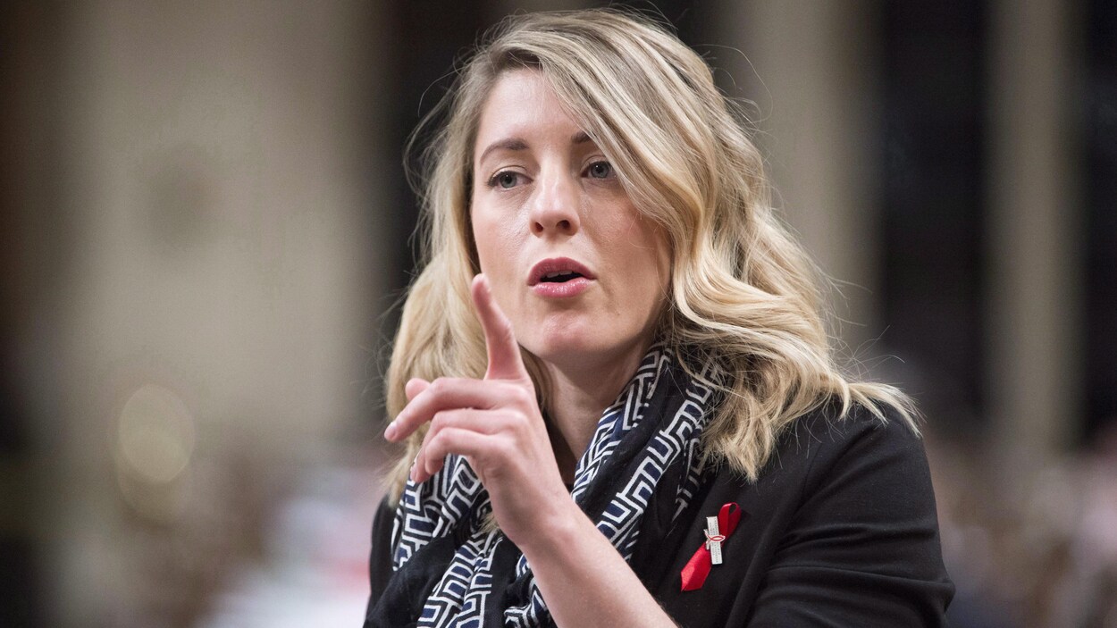 Mélanie Joly, ministre du Patrimoine canadien, debout à la Chambre des communes, répond à une question en pointant l'index. Mélanie Joly, ministre du Patrimoine canadien, debout à la Chambre des communes, répond à une question en pointant l'index.