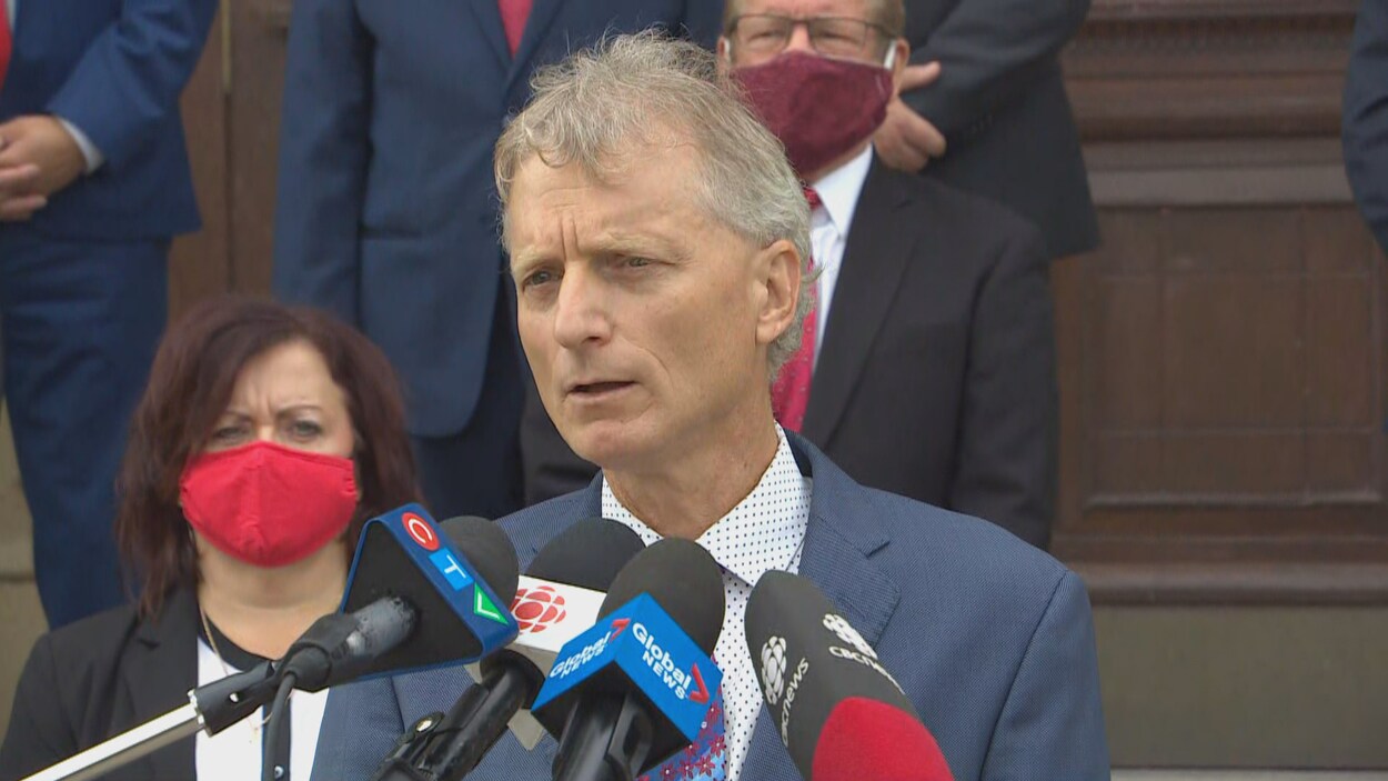 Roger Melanson donne une conférence de presse devant l'édifice de l'Assemblée législative.