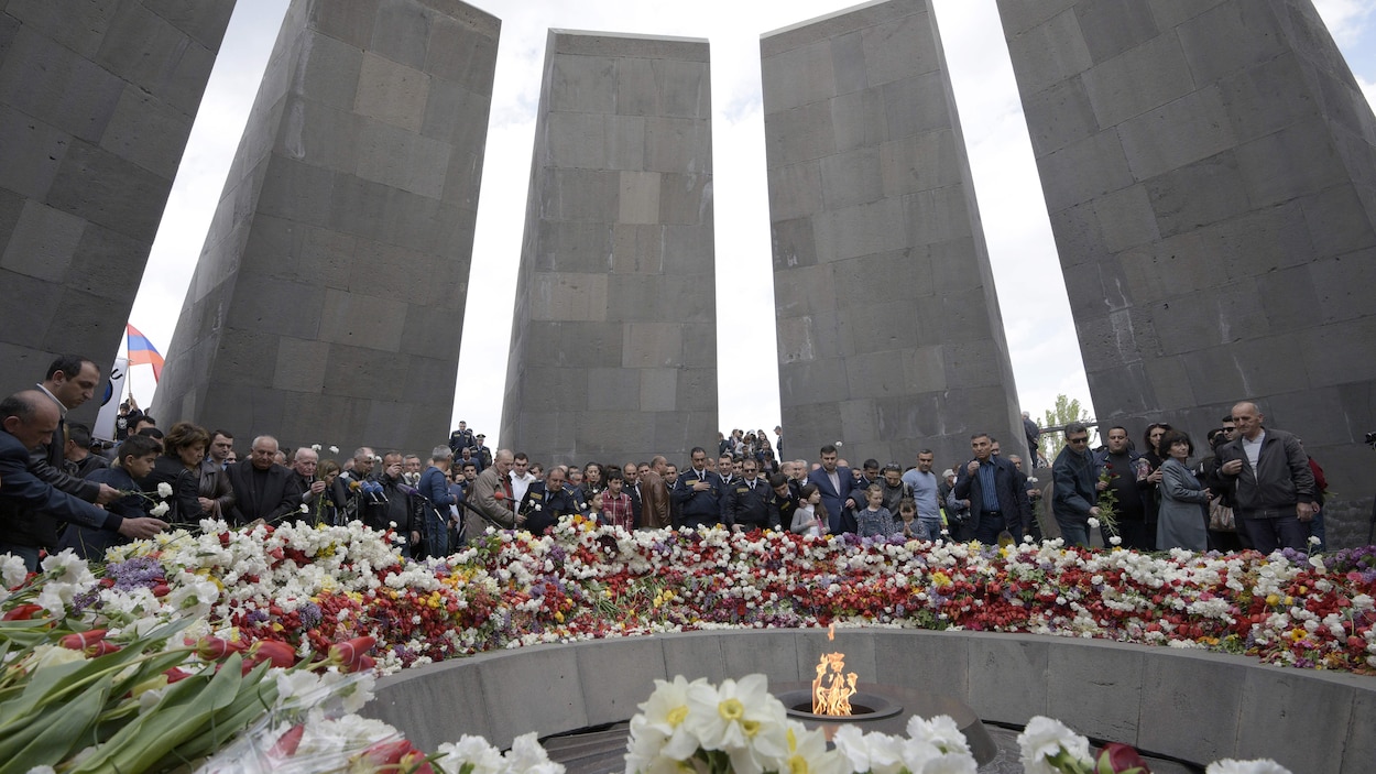 Plusieurs personnes réunies dans le mémorial rempli de fleurs Plusieurs personnes réunies dans le mémorial rempli de fleurs