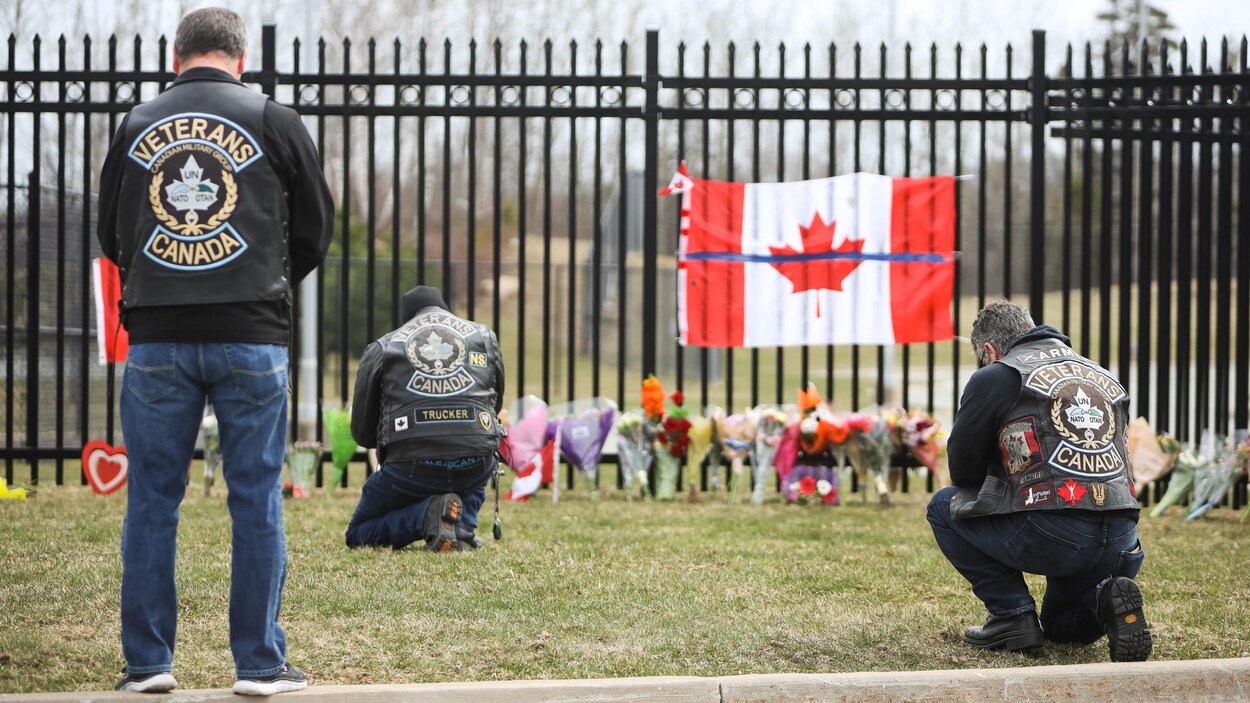 Des gens se recueillent devant un mémorial.