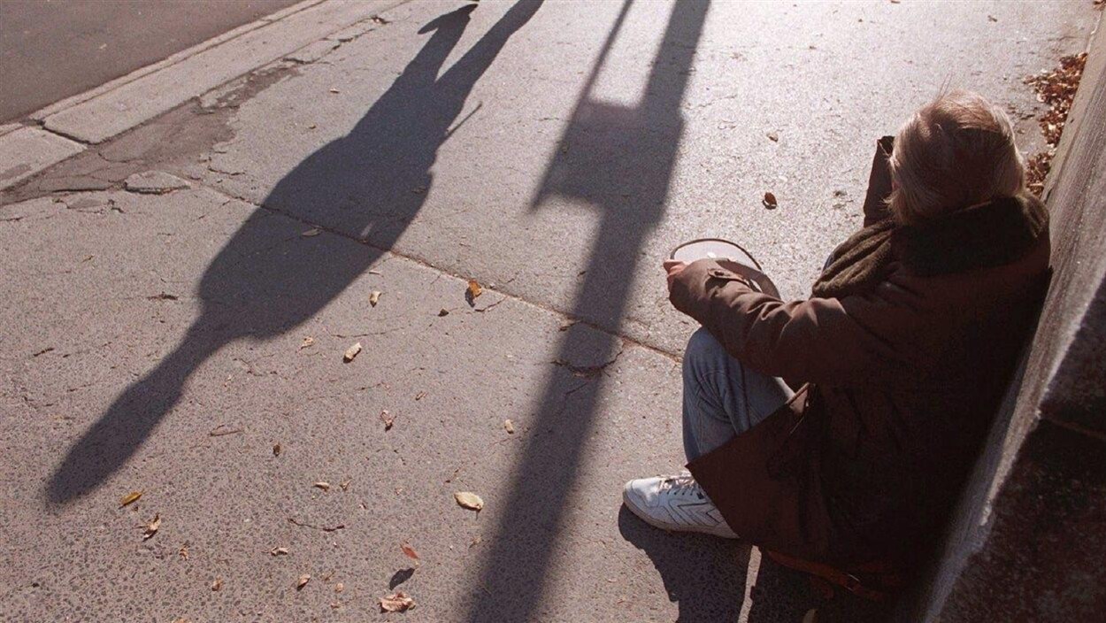 Une personne mendie dans une rue Une personne mendie dans une rue