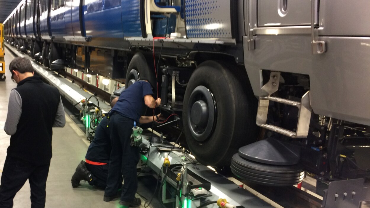Des employés de la maintenance de la STM examinent un train AZUR Des employés de la maintenance de la STM examinent un train AZUR
