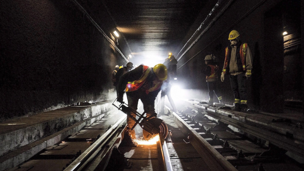 Un travailleur coupe un rail dans un tunnel du métro Un travailleur coupe un rail dans un tunnel du métro