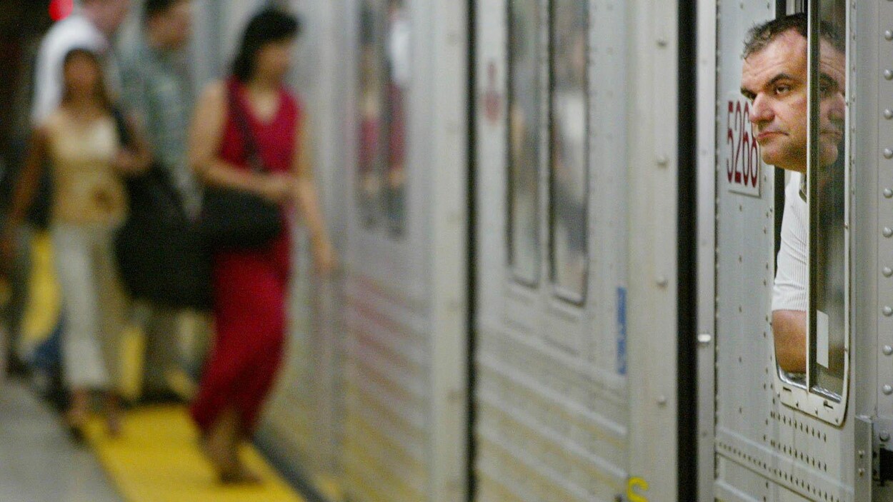 Photo d'usagers qui s'apprêtent à monter à bord du métro. Photo d'usagers qui s'apprêtent à monter à bord du métro.