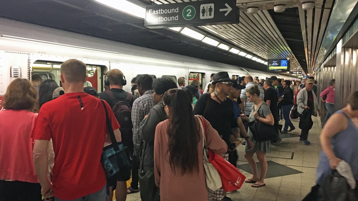 Photo d'usagers qui tentent de monter à bord d'une rame de métro