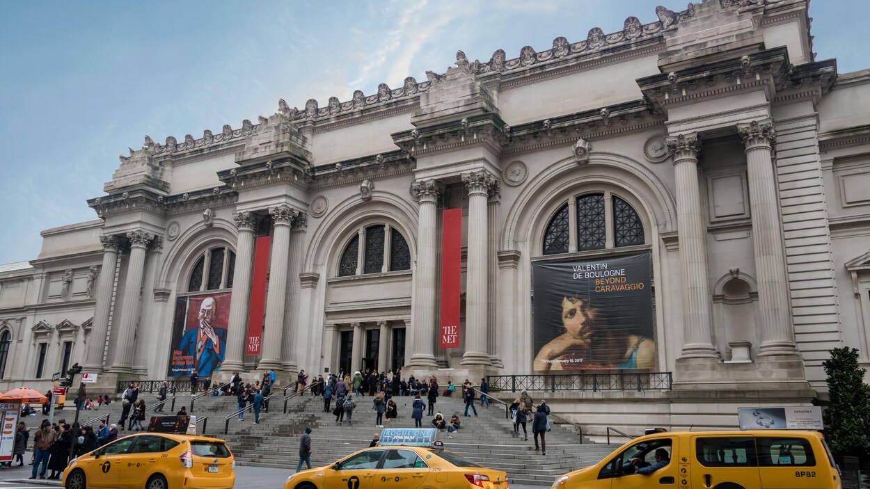 Des visiteurs devant l'édifice du musée.