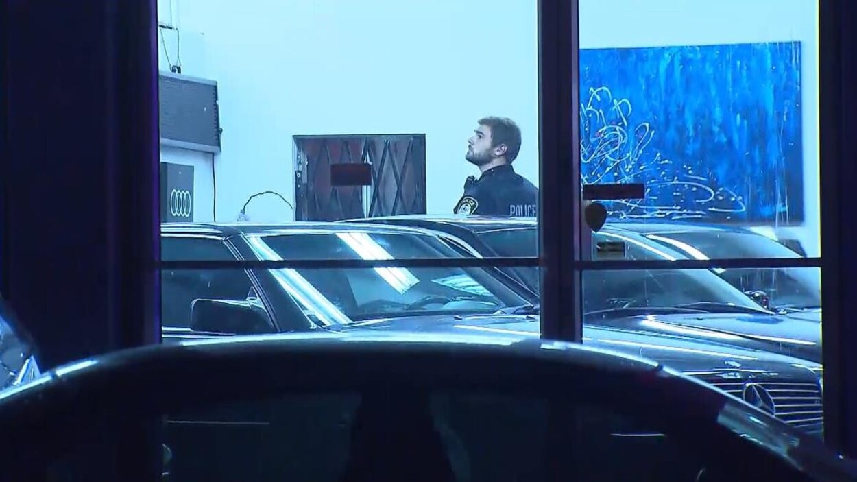 Un policier à l'intérieur du commerce de voiture.