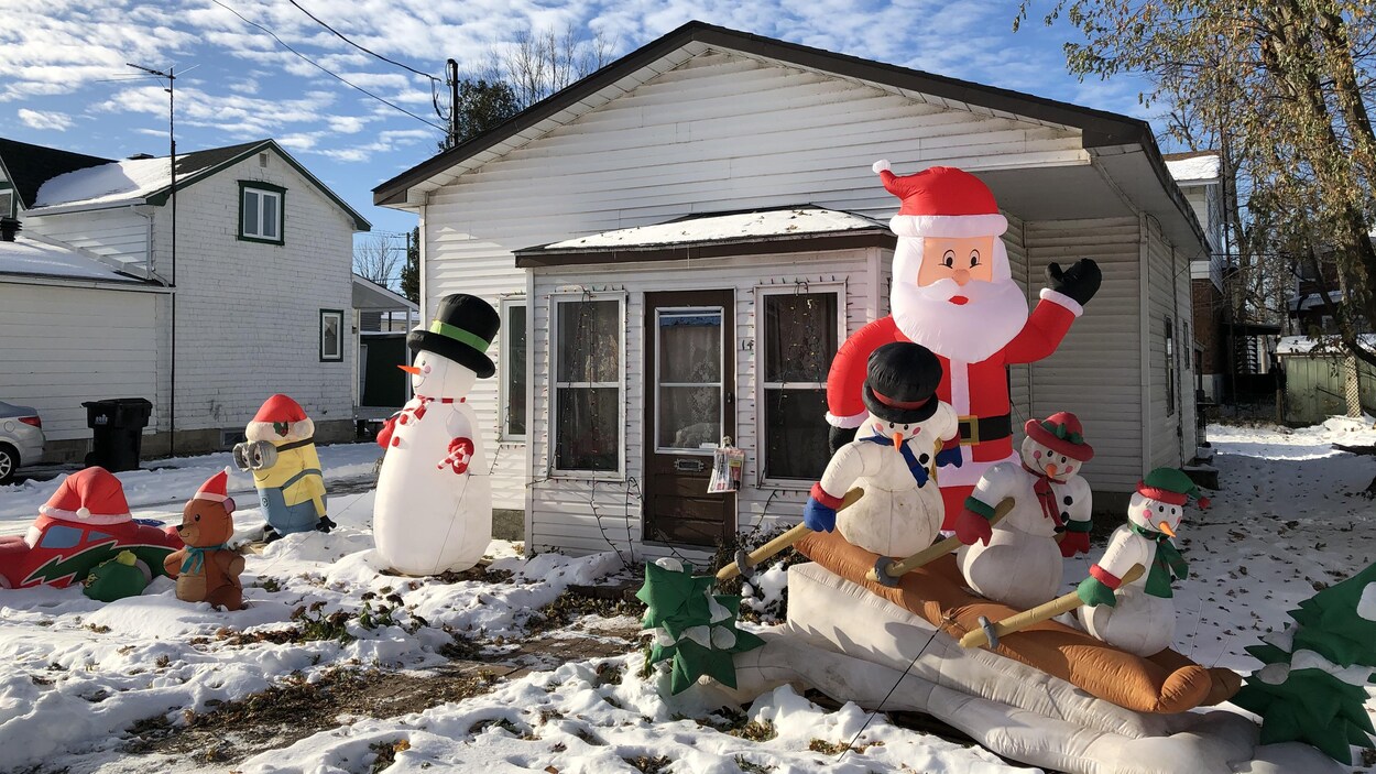 De multiples décorations de Noël gonflables sont installées devant la maison.
