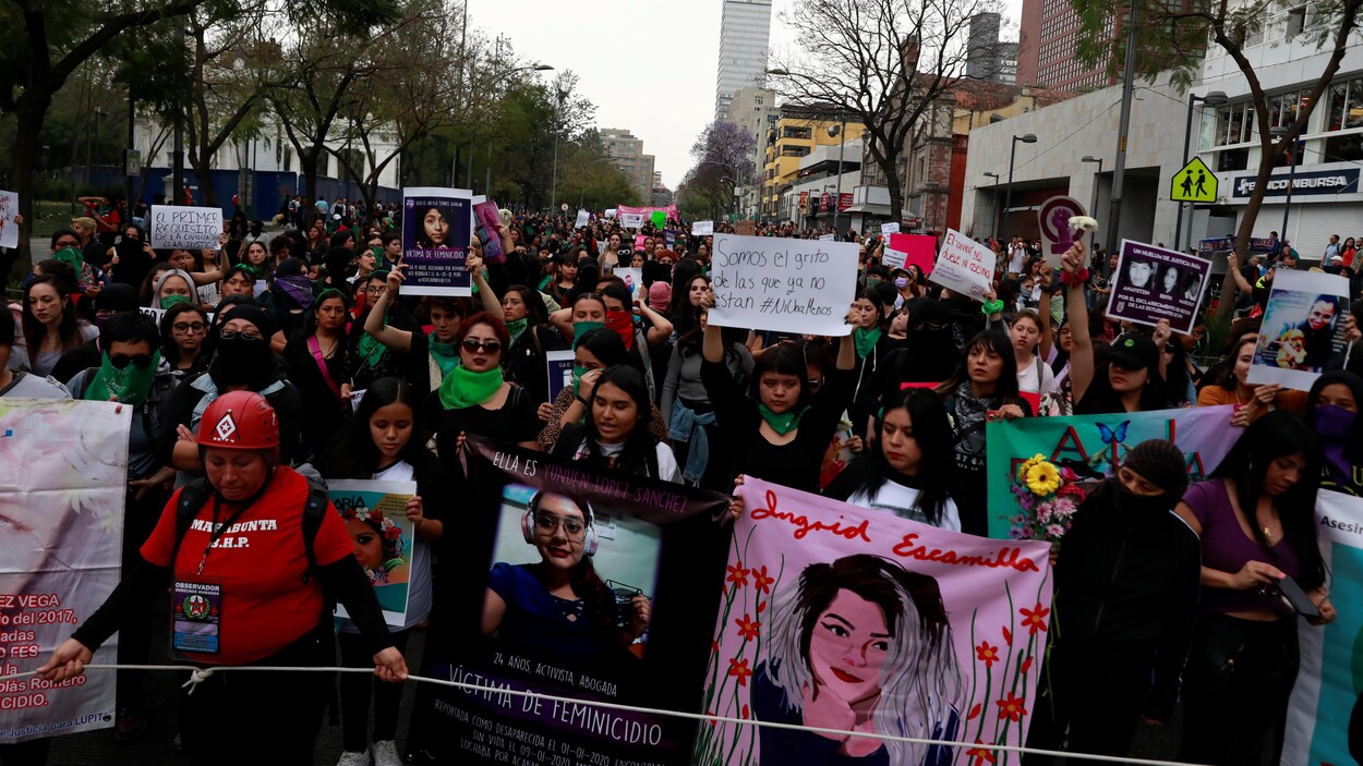 Des femmes manifestent en portant des banderoles.