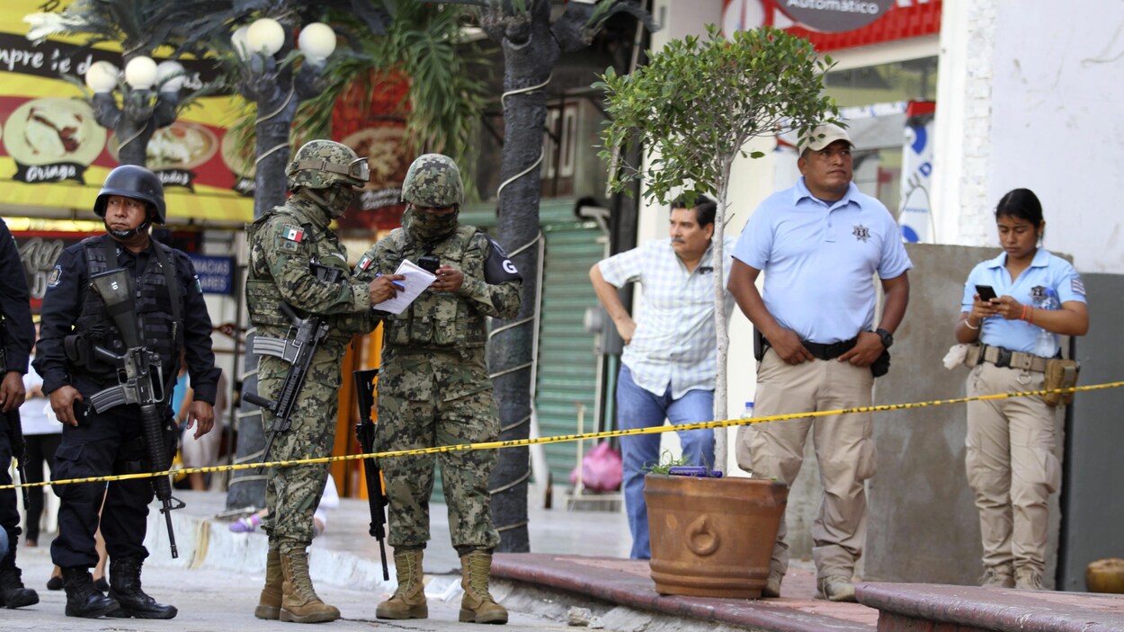 Des soldats de la Garde nationale ainsi que des officiers municipaux se tiennent dans un périmètre délimité par un cordon de sécurité.