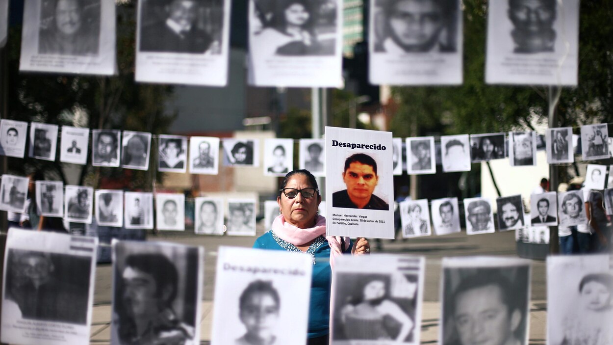 À Mexico, Maria Cristina tient une photo de son fils Manuel, elle et d'autres mères réclament justice pour leur enfant disparu.