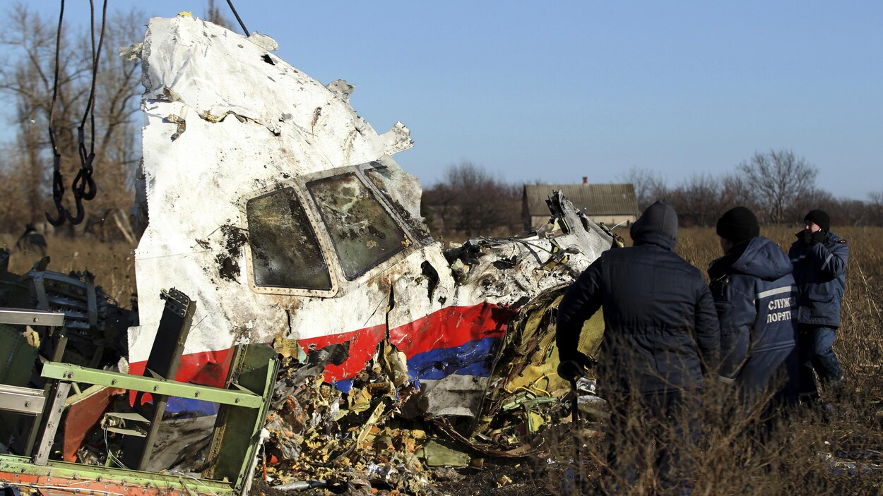 Des hommes inspectent la carcasse de l'avion.