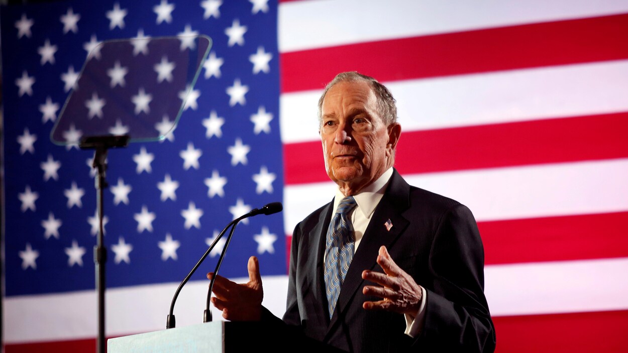 Michael Bloomberg parle lors d'un événement devant un drapeau américain.